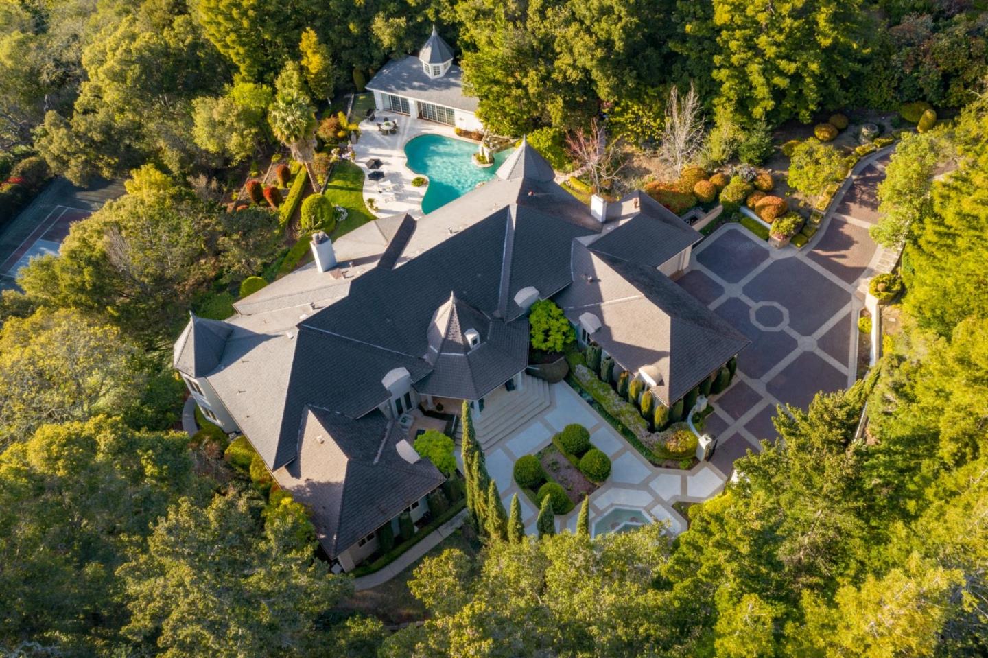 European grandeur and sophistication await in this spectacular gated estate, nestled in supreme privacy on 2.16 acres. Luxurious appointments include stained and leaded glass, crystal chandeliers, hand-forged ironwork, and custom wall coverings. Offering 5 bedrooms, 6.5 bathrooms, and over 9,100 sq ft, this estate includes an in-home apartment, while a 1-bed, 1-bath guest home offers 700 sq ft of living space. Entertain guests with easy thanks to gathering spaces scaled for entertaining, a gourmet kitchen, and incredible grounds with a pool. Work from home in style in the office, and unwind in the Parisian wine cellar and Old English bar. The master suite features a fireplace and spa-like bathroom, while 3 additional guest suites are perfect for friends and family alike. Convenient to Stanford University, Sand Hill Road, and both downtown Menlo Park and Palo Alto, this home is also served by acclaimed Las Lomitas schools, with top private schools close at hand.