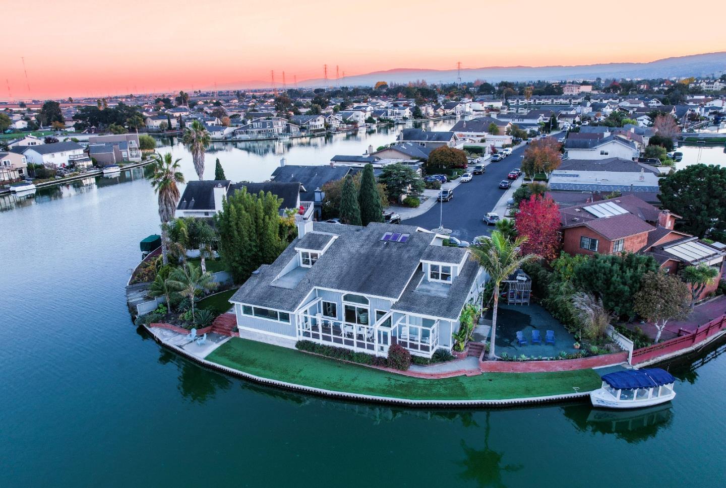 Located on one of the most desirable Isles in Foster City, this stunning two-story waterfront, over 4,000sqft, 5-bed, 3.5-bath, home w/custom wood finishes & hardwood floors, is unparalleled in elegance & modern comforts. Personally designed for extended water views, this sun-filled home infuses the best of indoor/outdoor living w/oversized glass doors that open to a gorgeous wind-protected deck from the great room, an intimate sitting area with w/fireplace, & custom built-ins. The gourmet kitchen is built for entertaining w/ a generous-sized stone-topped island, high-end appliances, & a walk-in pantry.  With 3 bedrooms on the main floor, including the luxurious owner's suite w/ outdoor access, a walk-in closet, and a luxurious spa-type bath with a glass shower. The upper level is designed around a large loft suited for a media room or additional guest space. Two Cape Cod-style sloped and angled ceiling bedrooms w/ an impressive Jack & Jill bathroom sure to make you take a second look.